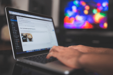 Working on a laptop in front of a television